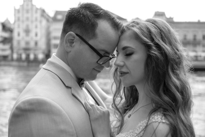 Brautpaar steht sich gegenüber und legt die Köpfe aneinander. Sie haben beide die Augen geschlossen.