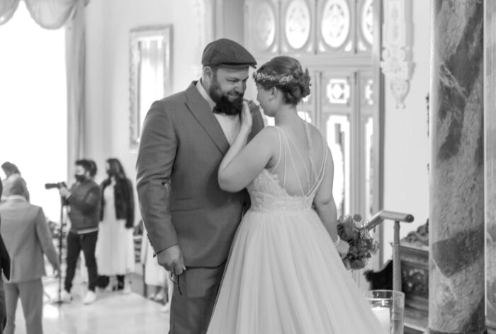 Brautpaar. Bräutigam schaut Braut tief in die Augen, sie wischt sich eine Träne weg