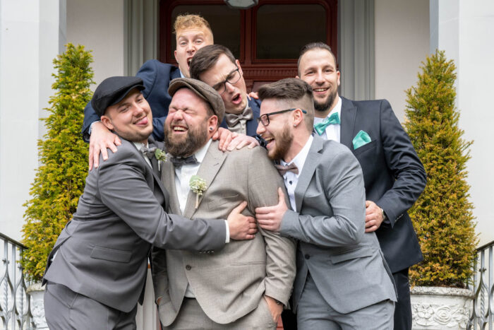 Trauzeuge und Kollegen im Gruppenbild machen Faxen