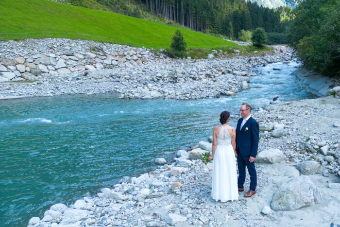Hochzeitspaar an Bach im Gebirge