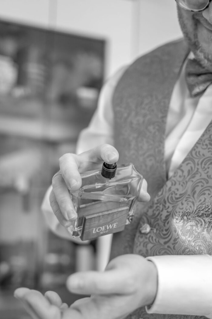 Bräutigam bei Getting Ready Parfüm sprühend sw