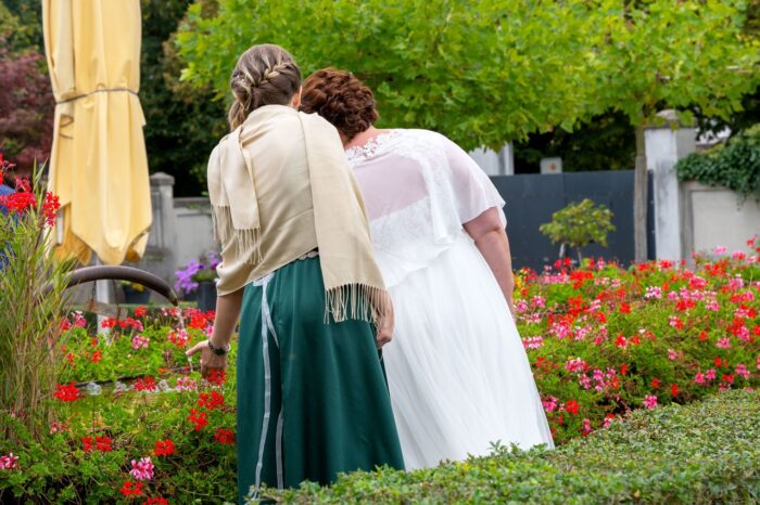 Braut mit Trauzeugin Rückenansicht bei Brunnen stehend