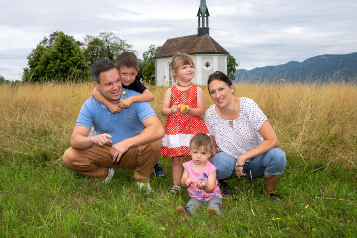 Familie mit drei Kindern vor Kapelle