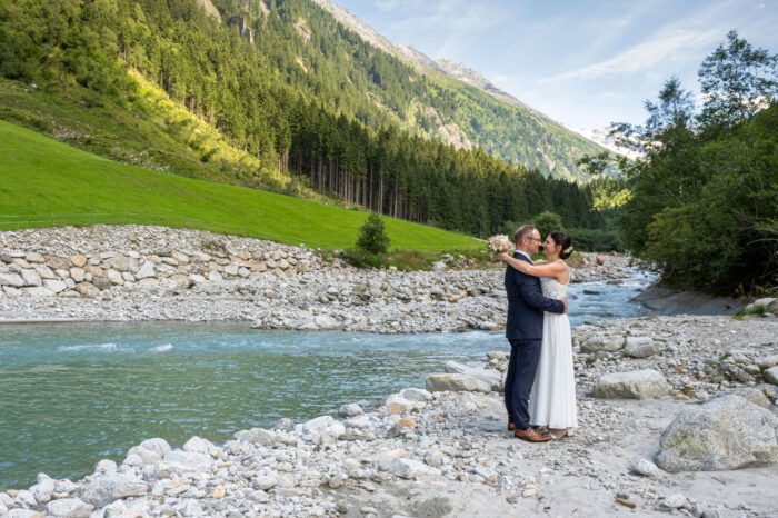 Hochzeitspaar an Bach im Gebirge